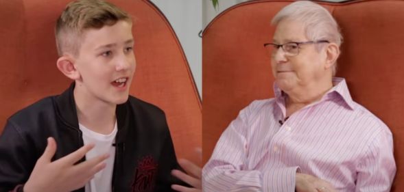 78-year-old Percy (right) and 13-year-old Louis (left) on an orange sofa talking about how they each experienced growing up and living as gay.