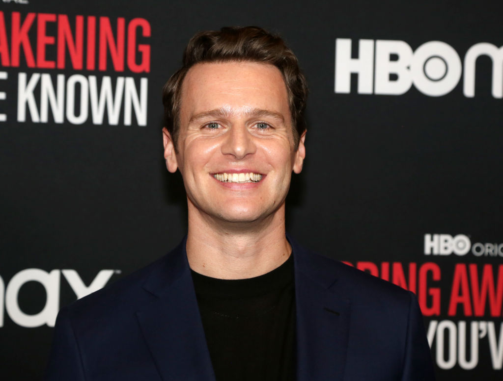 Jonathan Groff in a black t-shirt and navy blue jacket