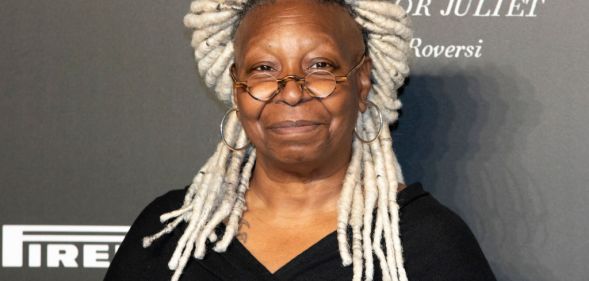 Whoopi Goldberg with blond dreadlocks wearing a black dress