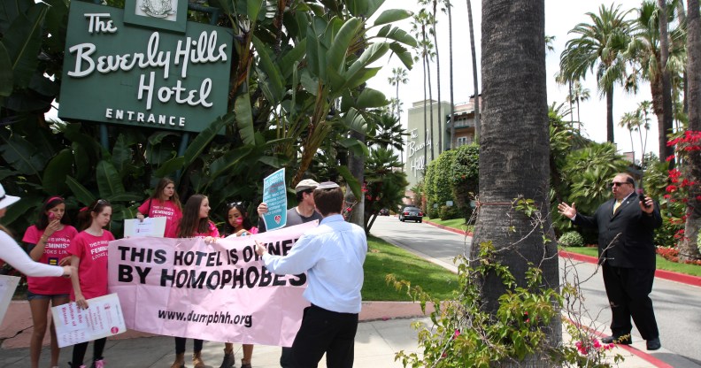 A security guard confronts demonstrators protesting the introduction of laws targeting women and LGBT people in Brunei, outside the Sultan-owned Beverley Hills Hotel