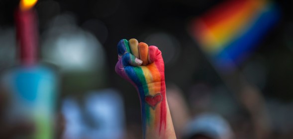 LGBT rainbow painted fist punched in air with celebration