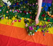 Demonstrators lay roses on a rainbow flag as they protest over an alleged Chechnya anti-gay purge outside the Russian Embassy in London on June 2, 2017.