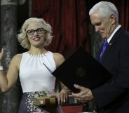 US Senator from Arizona Kirsten Sinema holds a law book as she is sworn in by Vice President Mike Pence on January 3, 2019.