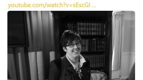 Lyra McKee smiling, leaning against a bookshelf