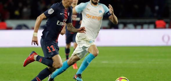 Paris Saint-Germain's Angel Di Maria vies with Marseille's Morgan Sanson for a ball.