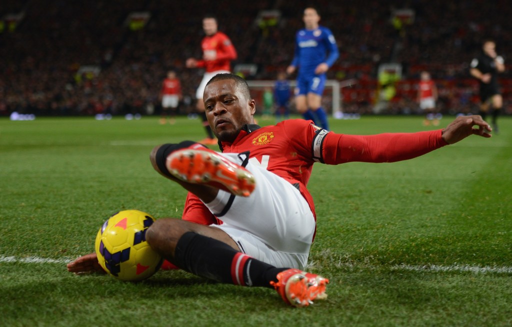 Patrice Evra of Manchester United tries to keep the ball in play during the Barclays Premier League match between Manchester United and Cardiff City at Old Trafford on January 28, 2014 in Manchester, England.