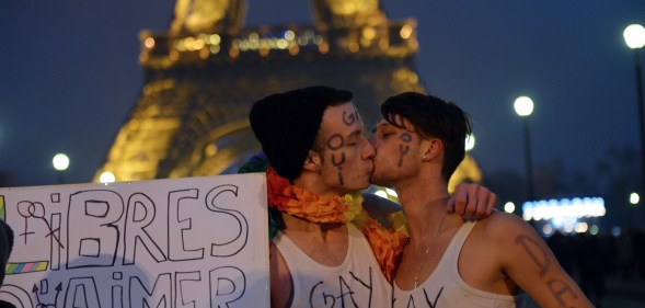 Gay couple kiss in Paris, France.