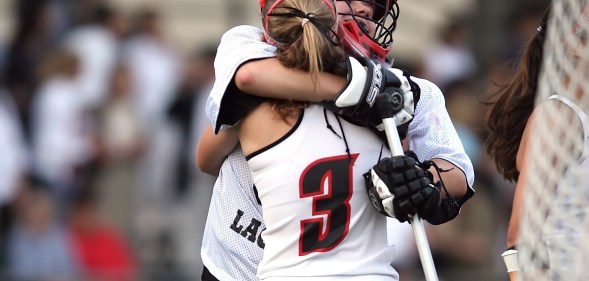 Two sports players hug in uniform