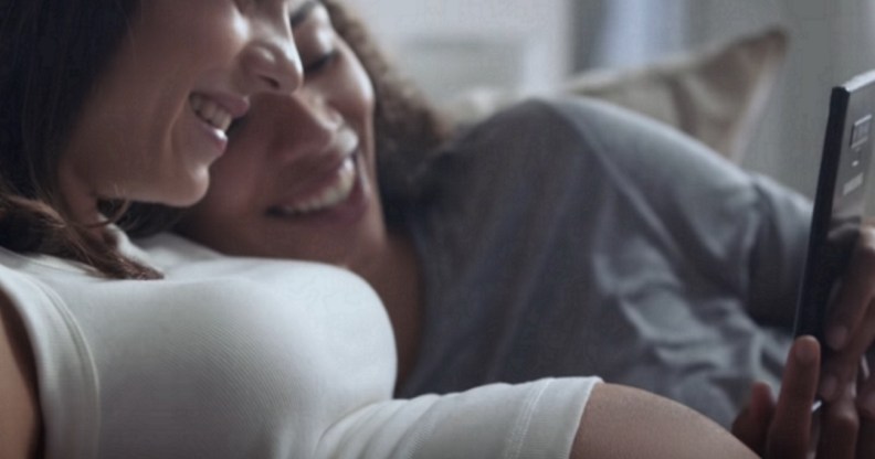 A lesbian biracial couple look at their baby on a Samsung phone in a Samsung advert