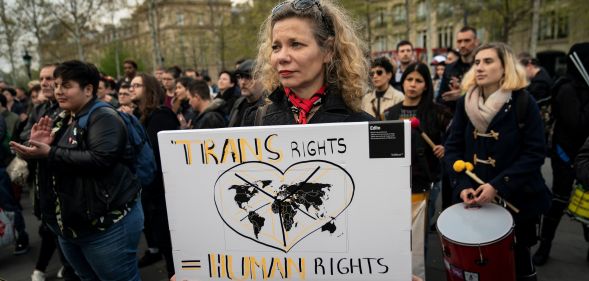 A woman holding a sign which reads "trans rights are human rights"