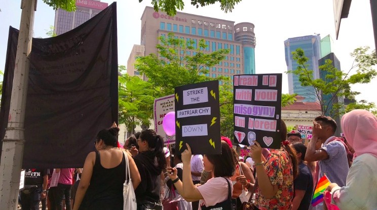 Protesters hold pro-equality signs and LGBT flags at the women's march in Malaysia