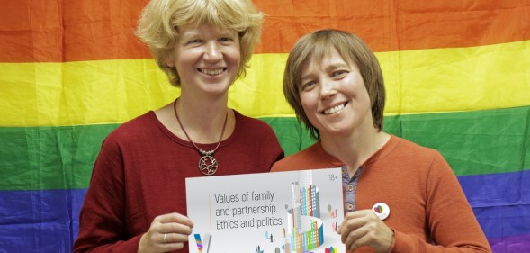 Founders Anna and Yulia pose with the logo for this year's conference, which did not go ahead as planned after LGBT+ activists were targeted in an attack.