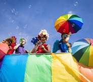 A giant rainbow flag being carried along Brighton seaside