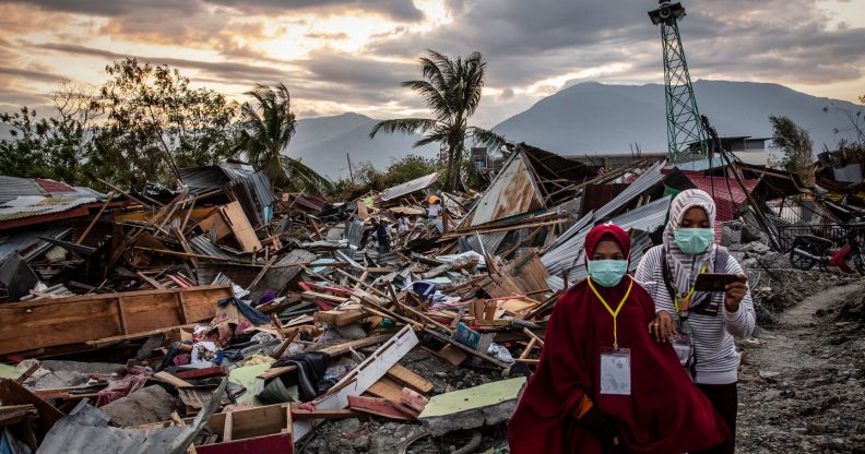 PALU, INDONESIA - OCTOBER 05: People walk along a damaged area which was hit by liquefaction in Petobo village following the earthquake on October 5, 2018 in Palu, Central Sulawesi, Indonesia. The death toll from last weeks earthquake and tsunami has risen to at least 1,558 but widely expected to rise as officials said on Friday the number of victims of the liquefaction could be up to a thousand. Power had returned to parts of the city and fuel shipments have begun to flow back but some affected towns remain inaccessible with the infrastructure badly damaged. A tsunami triggered by a magnitude 7.5 earthquake slammed into Indonesia's coastline on the island of Sulawesi which destroyed or damaged over 70,000 homes as tensions remain high with desperate survivors trying to secure basics like clean water and fuel for generators. (Photo by Ulet Ifansasti/Getty Images)