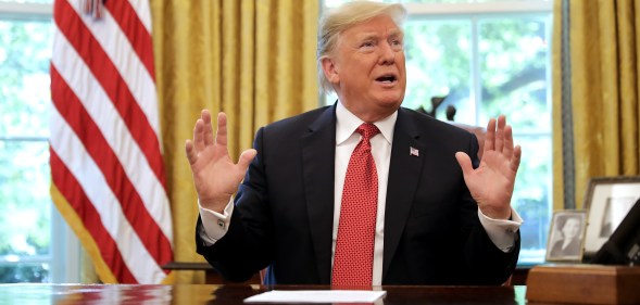 WASHINGTON, DC - OCTOBER 17: U.S. President Donald Trump talks to reporters while hosting workers and members of his cabinet for a meeting in the Oval Office at the White House October 17, 2018 in Washington, DC. The White House said the meeting was on “Cutting the Red Tape, Unleashing Economic Freedom." (Photo by Chip Somodevilla/Getty Images)