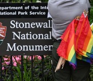 A National Park Service ranger places rainbow flags on the fence at the Stonewall National Monument in the West Village neighborhood of Greenwich Village in Lower Manhattan, New York City on June 19, 2019.