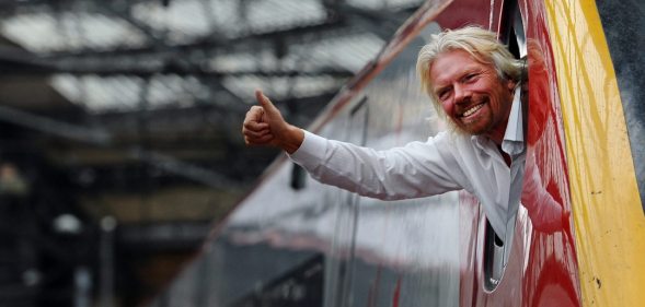 British entrepreneur Sir Richard Branson leans out of the window of the driver's cab on board a Virgin Pendolino train at Lime Street Station in Liverpool, north-west England, on March 13, 2012, as he prepares to launch a Global Entrepreneurship Congress. The event aims to be the largest gathering of start-up champions from around the world. AFP PHOTO/PAUL ELLIS (Photo credit should read PAUL ELLIS/AFP/Getty Images)