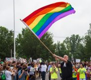 Principal Pete Cahall, waves a rainbow flag, symbolizing gay pride, at a rally of about 1000 Woodrow Wilson High School students and gay supporters June 9, 2014 at Woodrow Wilson High School in Washington, DC. The rally was held to counter a planned protest by Westboro Baptist Church, the Kansas-based organization known for anti-gay picketing at funerals. AFP PHOTO/Paul J. Richards (Photo credit should read PAUL J. RICHARDS/AFP/Getty Images)