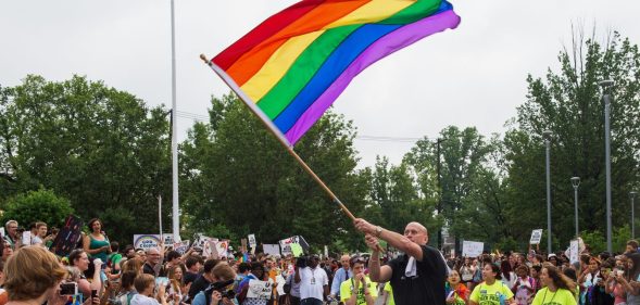 Principal Pete Cahall, waves a rainbow flag, symbolizing gay pride, at a rally of about 1000 Woodrow Wilson High School students and gay supporters June 9, 2014 at Woodrow Wilson High School in Washington, DC. The rally was held to counter a planned protest by Westboro Baptist Church, the Kansas-based organization known for anti-gay picketing at funerals. AFP PHOTO/Paul J. Richards (Photo credit should read PAUL J. RICHARDS/AFP/Getty Images)