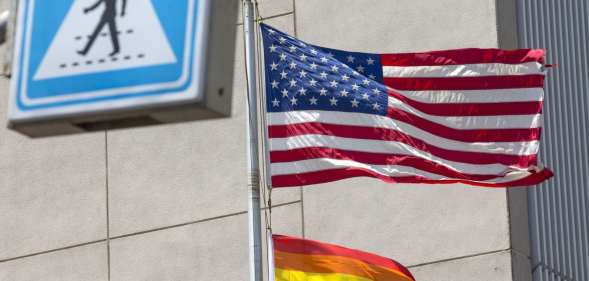 A Pride flag is raised next to the US flag.