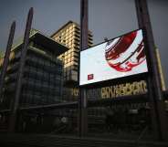 SALFORD, ENGLAND - JANUARY 05: A giant outdoor television screen broadcasts the BBC News at Media City in Salford Quays which is home to the BBC, ITV television studios and also houses many media production companies on January 5, 2015 in Salford, England. The BBC and neighbour ITV Granada with its cobbled street studios of ITV soap opera 'Coronation Street', line the banks of the Manchester Ship Canal.