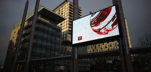 SALFORD, ENGLAND - JANUARY 05: A giant outdoor television screen broadcasts the BBC News at Media City in Salford Quays which is home to the BBC, ITV television studios and also houses many media production companies on January 5, 2015 in Salford, England. The BBC and neighbour ITV Granada with its cobbled street studios of ITV soap opera 'Coronation Street', line the banks of the Manchester Ship Canal.