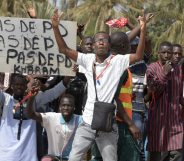 A protestor gestures on January 22, 2015 in Dakar during a demonstration against homosexuality. Under Senegalese law, anyone convicted of an "improper or unnatural act with a person of the same sex" faces up to five years in jail. The government has repeatedly ruled out legalising homosexuality in the deeply conservative Muslim-majority country. Banner reads "No fag". / AFP / SEYLLOU (Photo credit should read SEYLLOU/AFP/Getty Images)