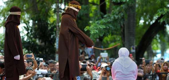 A woman in Aceh is caned 100 times for having sex outside marriage (CHAIDEER MAHYUDDIN/AFP/Getty)