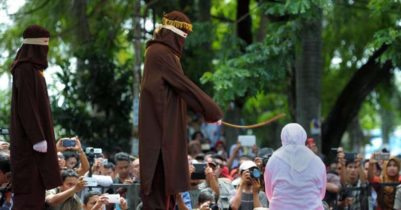 A woman in Aceh is caned 100 times for having sex outside marriage (CHAIDEER MAHYUDDIN/AFP/Getty)