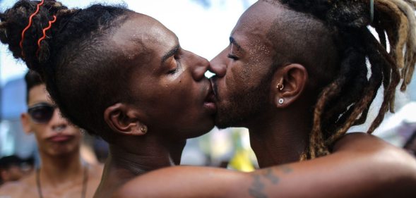 RIO DE JANEIRO, BRAZIL - DECEMBER 11: Revelers kiss during the annual gay pride parade on Copacabana beach December 11, 2016 in Rio de Janeiro, Brazil. Marchers called for expanded rights and protection from violence for those in the LGBT (Lesbian, Gay, Bisexual and Transgender) community. (Photo by Mario Tama/Getty Images)