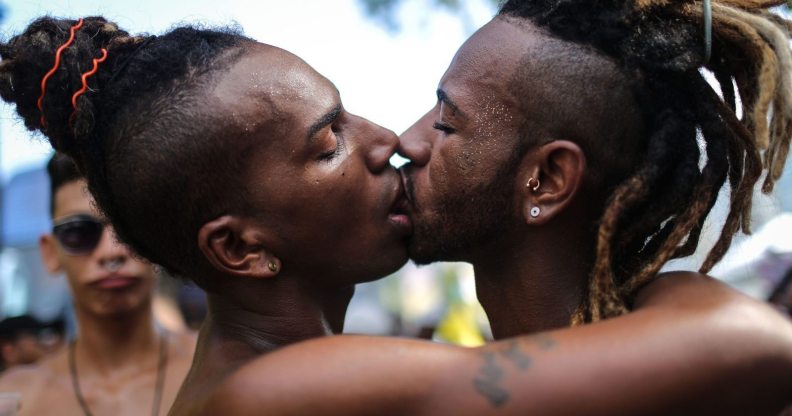 RIO DE JANEIRO, BRAZIL - DECEMBER 11: Revelers kiss during the annual gay pride parade on Copacabana beach December 11, 2016 in Rio de Janeiro, Brazil. Marchers called for expanded rights and protection from violence for those in the LGBT (Lesbian, Gay, Bisexual and Transgender) community. (Photo by Mario Tama/Getty Images)