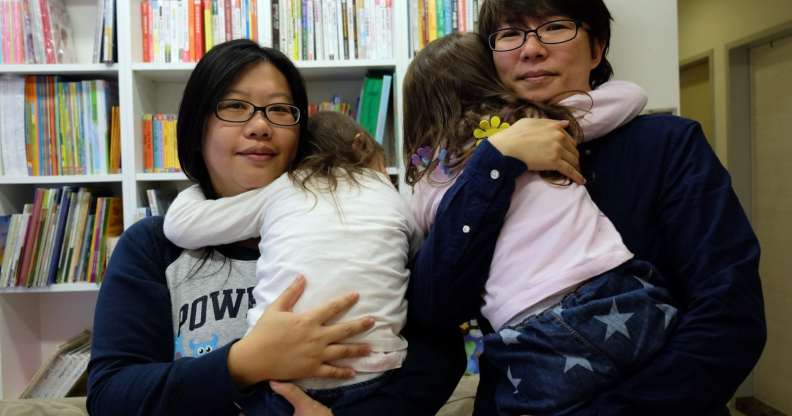 Same-sex couple Hope Chen (L), 37, and Zoro Wen, 34, pose with their twin daughters at their home in Taoyuan, northern Taiwan