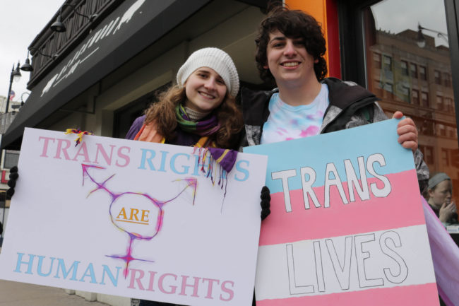 Protesters holding up pro trans signs