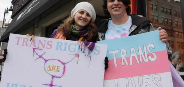 Protesters holding up pro trans signs