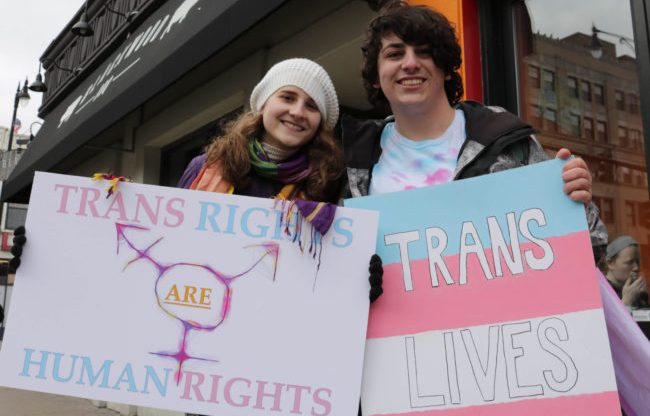 Protesters holding up pro trans signs
