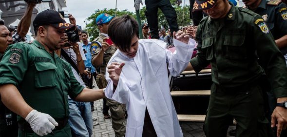 Indonesian man escorted after public caning for having gay sex BANDA ACEH, INDONESIA - MAY 23: An indonesian man escorted by the sharia police after get caning in public from an executor known as 'algojo' for having gay sex, which is against Sharia law at Syuhada mosque on May 23, 2017 in Banda Aceh, Indonesia. The two young gay men, aged 20 and 23, were caned 85 times each in the Indonesian province of Aceh during a public ceremony after being caught having sex last week. It was the first time gay men have been caned under Sharia law as gay sex is not illegal in most of Indonesia except for Aceh, which is the only province which exercises Islamic law. The punishment came a day after the police arrested 141 men at a sauna in the capital Jakarta on Monday due to suspicion of having a gay sex party, the latest crackdown on homosexuality in the country. (Photo by Ulet Ifansasti/Getty Images)