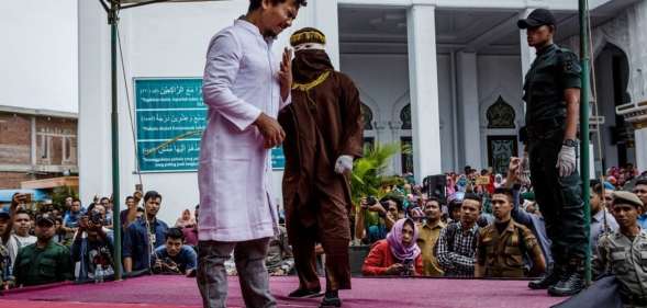 BANDA ACEH, INDONESIA - MAY 23: An acehnese man gets caning in public from an executor known as 'algojo' for spending time with a woman who is not his wife, which is against Sharia law at Syuhada mosque on May 23, 2017 in Banda Aceh, Indonesia. Indonesia's Aceh Province, on the northern tip of Sumatra island, is among the only place in the Muslim-majority country which implements the strict version of Sharia Law. Public canings take place regularly in Aceh for a range of offenses from adultery to homosexuality to selling alcohol, while women are required to dress modestly and Shariah police officers patrol the streets and conduct raids to hunt for immoral activities. More than 90 per cent of the 255 million people who live in Indonesia describe themselves as Muslim, but the vast majority practice a moderate form. According to reports, the Shariah Law in Aceh began in 2001, after receiving authorization from Indonesia's central government, which was intent on calming separatist sentiment in the conservative region while today. (Photo by Ulet Ifansasti/Getty Images)