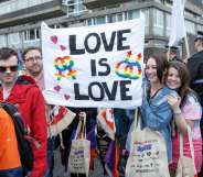 People hold up a sign during Glasgow Pride.