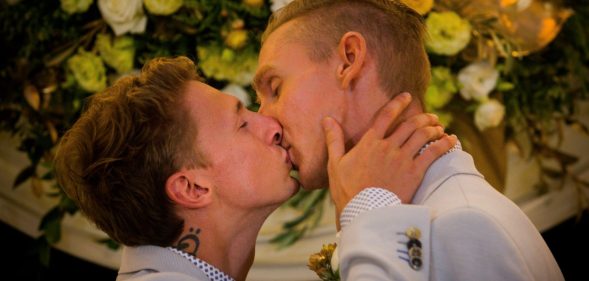 Australian Commonwealth Games sprinter Craig Burns (R) and fiance Luke Sullivan (L) kiss after exchanging vows at their marriage ceremony at Summergrove Estate, New South Wales on January 9, 2018. Australia officially become the 26th country to legalise same-sex marriage after the law was passed on December 9, 2017, with the overwhelming backing of the Federal Parliament. / AFP PHOTO / Patrick HAMILTON (Photo credit should read