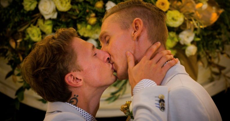 Australian Commonwealth Games sprinter Craig Burns (R) and fiance Luke Sullivan (L) kiss after exchanging vows at their marriage ceremony at Summergrove Estate, New South Wales on January 9, 2018. Australia officially become the 26th country to legalise same-sex marriage after the law was passed on December 9, 2017, with the overwhelming backing of the Federal Parliament. / AFP PHOTO / Patrick HAMILTON (Photo credit should read