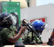 Zambian riot policeman gets ready to fire a tear gas canister to disperser Zambian traders and vendors during a march to protest over a ban on street commerce aimed at curbing a deadly cholera outbreak, in Lusaka, on January 15, 2018. Police in Zambia's capital Lusaka fired tear gas at angry traders marching to the president's office. The 500-strong crowd was trying to deliver a petition to President Edgar Lungu who has become the public face of the campaign against the outbreak that has claimed at least 70 lives since September. Authorities have banned several street markets in Lusaka in an effort to reduce the volume of food and drink sold in unsanitary open-air locations, which are particularly vulnerable to the spread of cholera. / AFP PHOTO / DAWOOD SALIM (Photo credit should read DAWOOD SALIM/AFP/Getty Images)