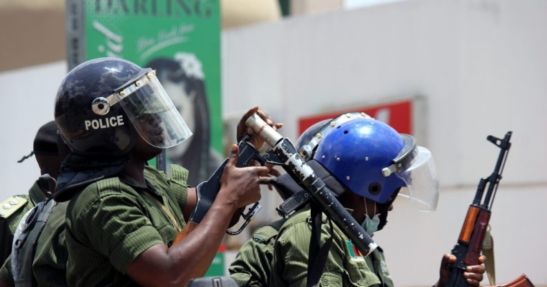 Zambian riot policeman gets ready to fire a tear gas canister to disperser Zambian traders and vendors during a march to protest over a ban on street commerce aimed at curbing a deadly cholera outbreak, in Lusaka, on January 15, 2018. Police in Zambia's capital Lusaka fired tear gas at angry traders marching to the president's office. The 500-strong crowd was trying to deliver a petition to President Edgar Lungu who has become the public face of the campaign against the outbreak that has claimed at least 70 lives since September. Authorities have banned several street markets in Lusaka in an effort to reduce the volume of food and drink sold in unsanitary open-air locations, which are particularly vulnerable to the spread of cholera. / AFP PHOTO / DAWOOD SALIM (Photo credit should read DAWOOD SALIM/AFP/Getty Images)