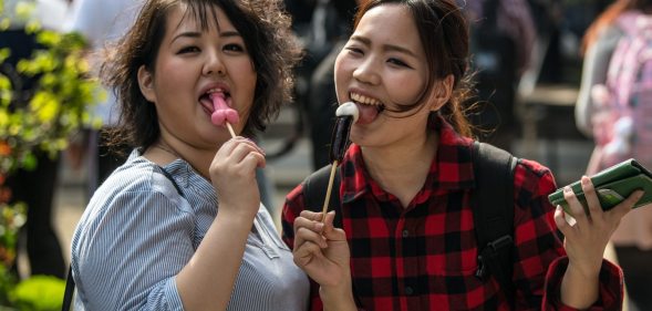 KAWASAKI, JAPAN - APRIL 01: (EDITORS NOTE: Image contains suggestive content.) Women react to the camera as they eat phallic-shaped lollipops during Kanamara Matsuri (Festival of the Steel Phallus) on April 1, 2018 in Kawasaki, Japan. The Kanamara Festival is held annually on the first Sunday of April. The penis is the central theme of the festival, focused at the local penis-venerating shrine which was once frequented by prostitutes who came to pray for business prosperity and protection against sexually transmitted diseases. Today the festival has become a popular tourist attraction and is used to raise money for HIV awareness and research. (Photo by Carl Court/Getty Images)