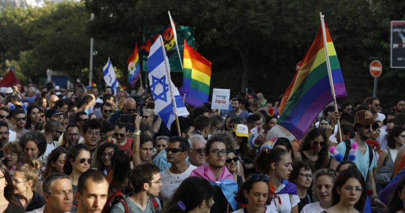 Participants wave Israeli and LGBT pride rainbow flags during Jerusalem's annual Gay Pride parade on August 2, 2018.