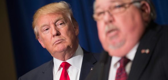 DUBUQUE, IA - AUGUST 25: Republican presidential candidate Donald Trump (L) listens as Sam Clovis speaks at a press conference at the Grand River Center on August 25, 2015 in Dubuque, Iowa. Clovis recently quit his position as Iowa campaign chairman for Rick Perry. Trump leads most polls in the race for the Republican presidential nomination. (Photo by Scott Olson/Getty Images)