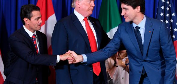 Mexico's President Enrique Pena Nieto shakes hands with Canadian Prime Minister Justin Trudeau next to US President Donald Trump after signing the USMCA agreement