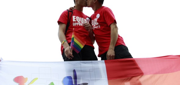 A gay couple kiss at an anti-discrimination parade in Chine, where a writer was recently jailed for including gay sex scenes in her novel.