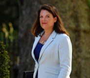 Caroline Nokes wearing a white jacket walking into 10 Downing Street