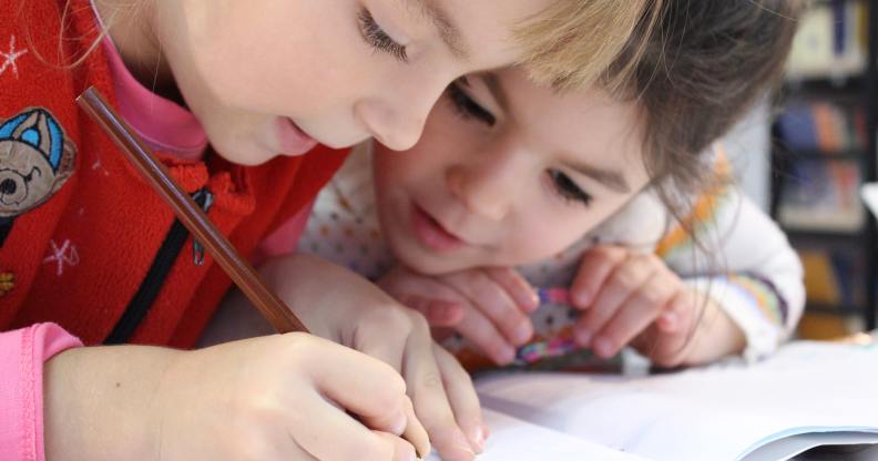 Two children draw a picture together, similar to the images Russian Police seized from a school.