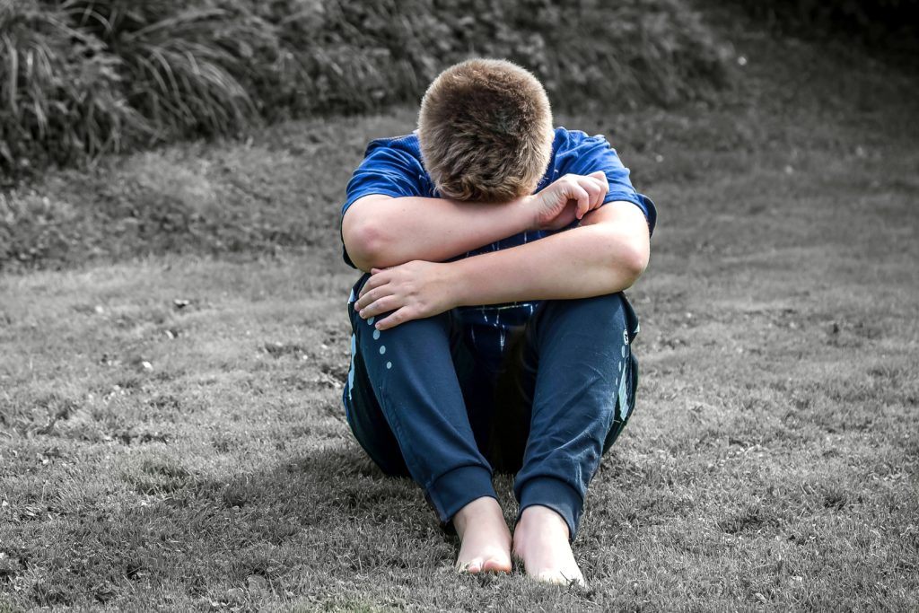 Boy holding his head in his hands